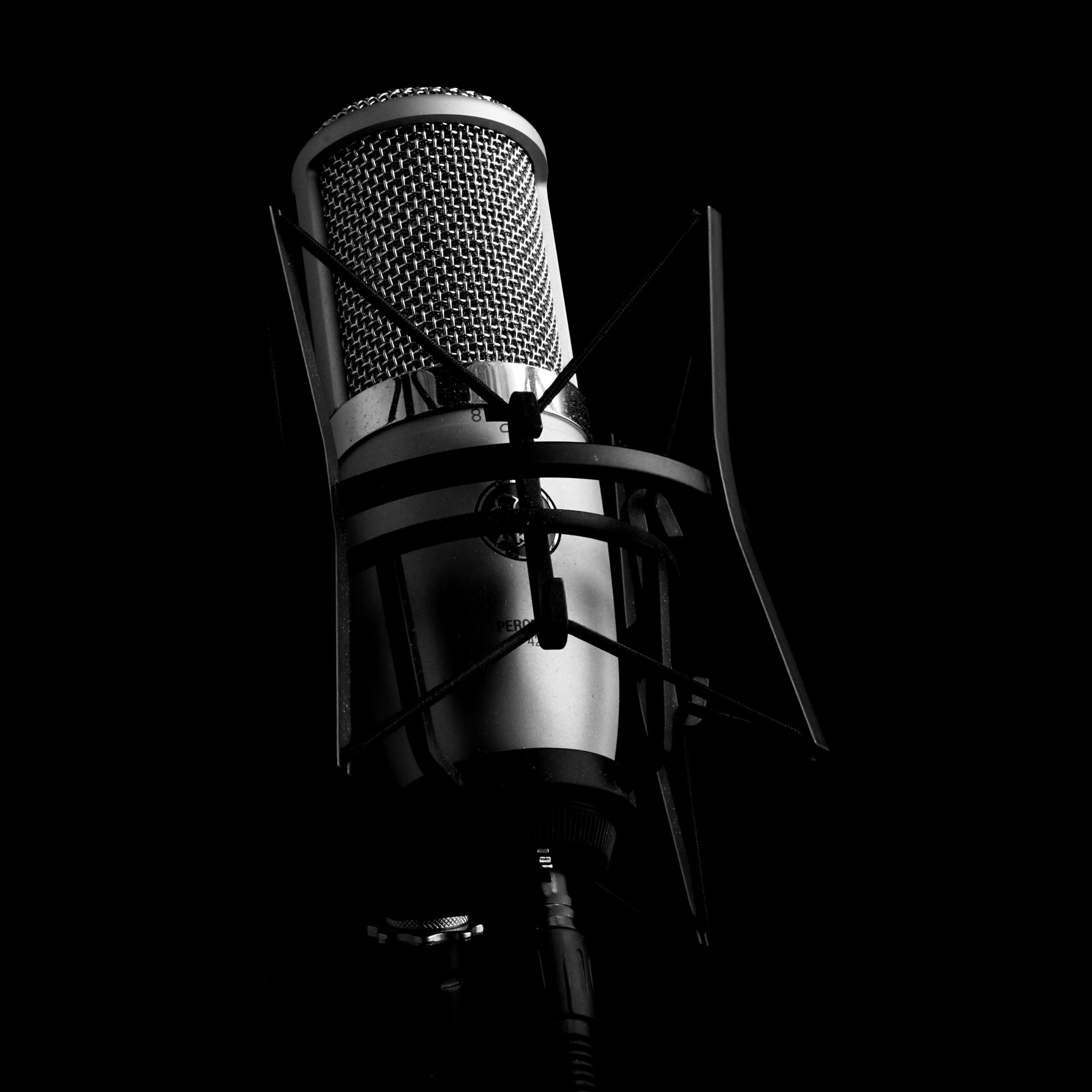 Close-up view of a professional studio microphone set against a black background, ideal for audio and recording themes.